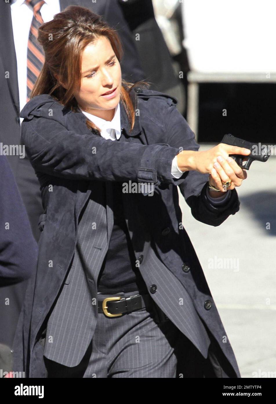 Actress Tea Leoni, who appears to play a police officer, points a prop
