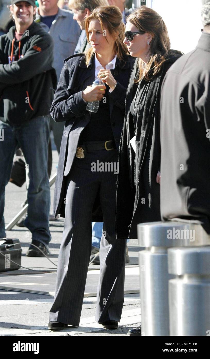 Actress Tea Leoni, who appears to play a police officer, points a prop