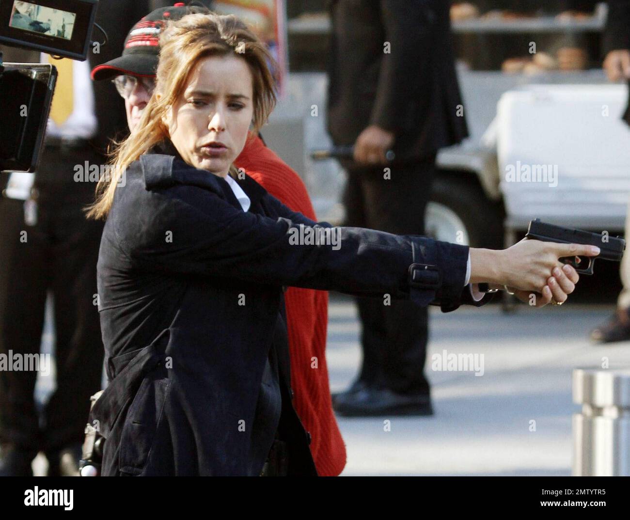 Actress Tea Leoni, who appears to play a police officer, points a prop