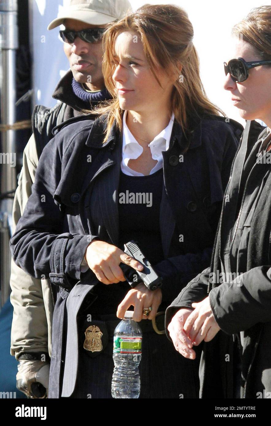Actress Tea Leoni, who appears to play a police officer, points a prop
