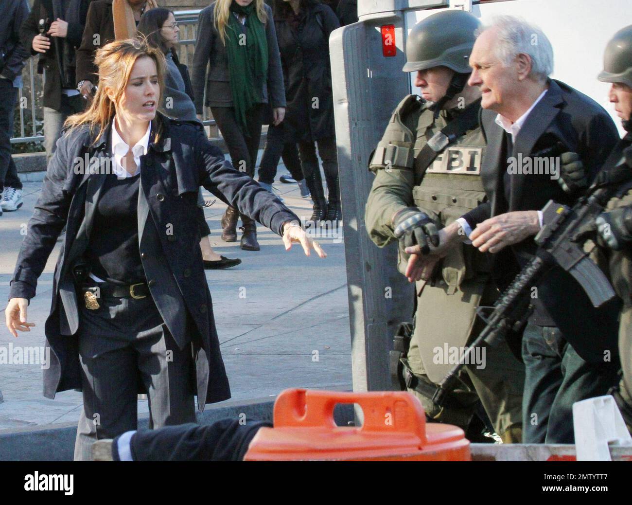 Actress Tea Leoni, who appears to play a police officer, points a prop