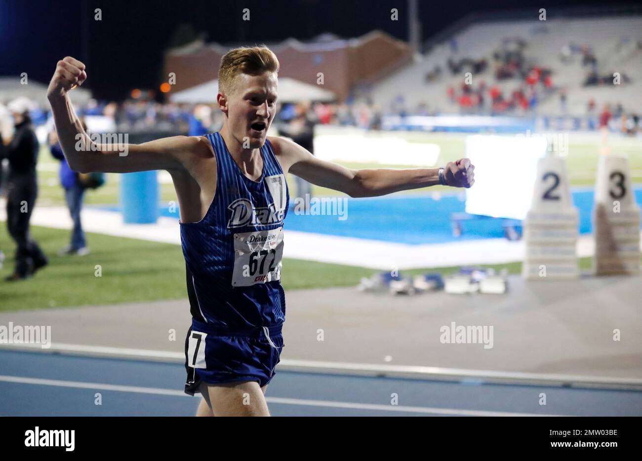 Drake's Reed Fischer celebrates after winning the men's 5,000meter run