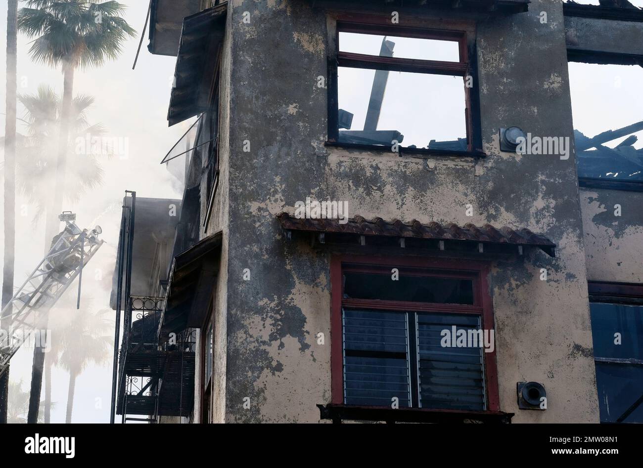 As smoke continues to billow from a burning building a Los Angeles fire ...