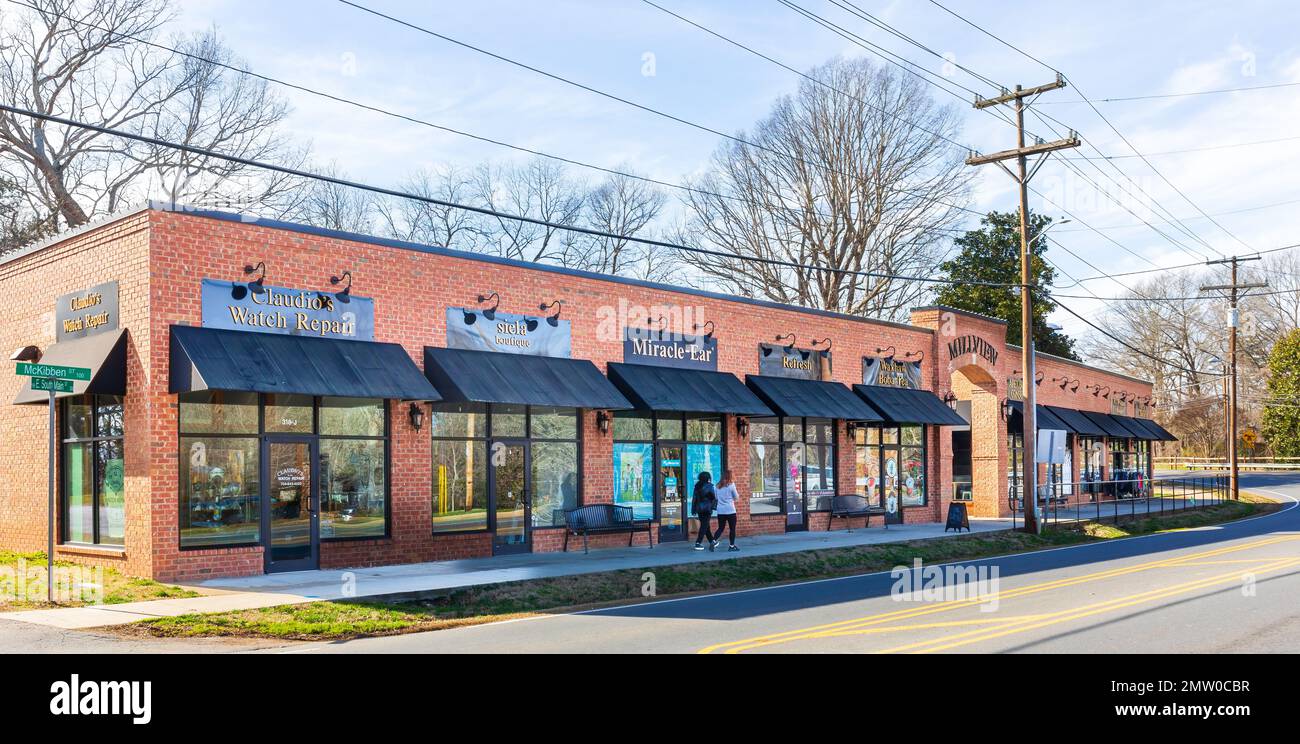 WAXHAW, NC, USA-28 JAN 2023: Millview, one-story retail and business building on South Main St., , across from The Mill on Main.  Two women walking. Stock Photo