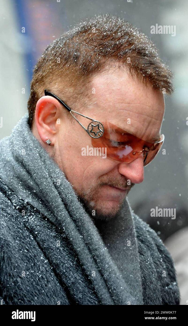 Bono of U2 greets fans on a cold and snowy day in New York City and shares a kiss with one of them before taking the first of a five night residency on the Late Show with David Letterman.  New York, NY 3/2/09 Stock Photo