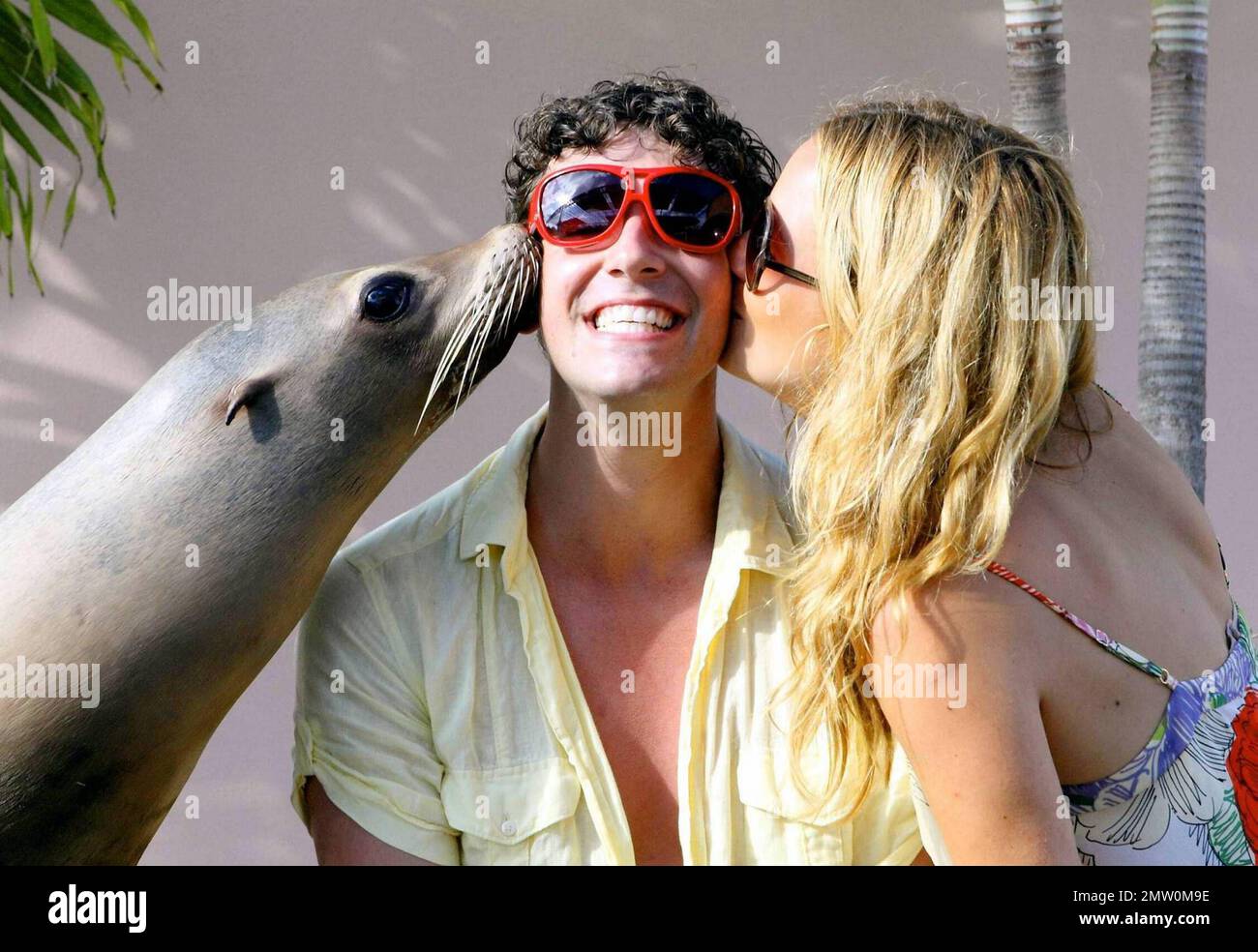 Becki Newton and Michael Urie interact with a sea lion during the