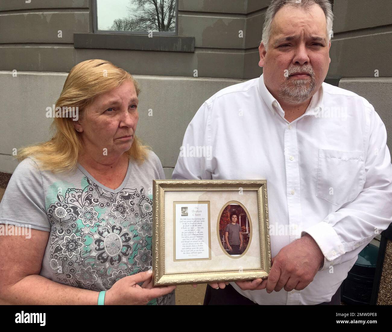 Ann and Mark Phillips hold a picture of their late son Joe outside