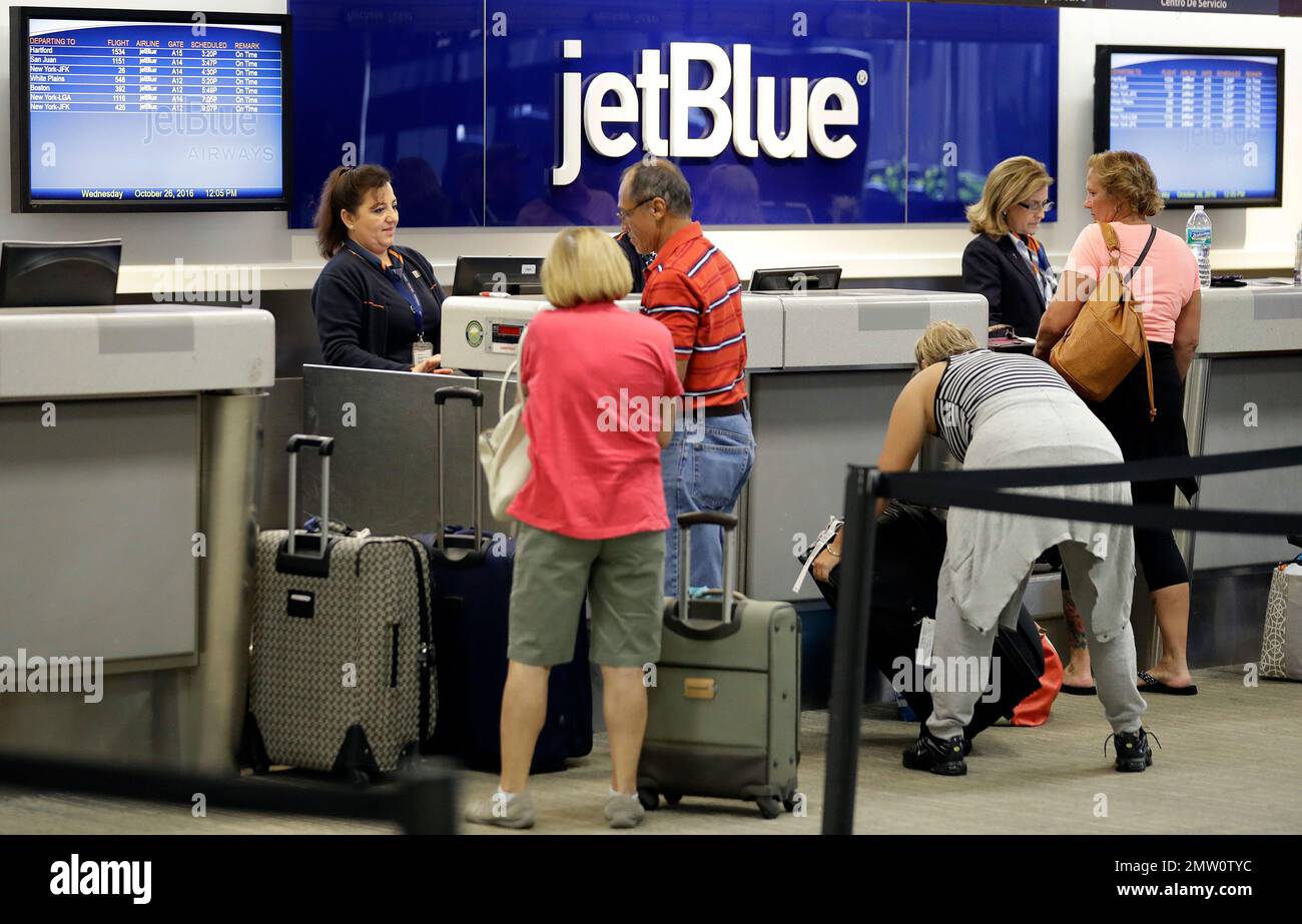 In this Wednesday, Oct. 26, 2016, photo, JetBlue Airways ticket agents assist passengers at the