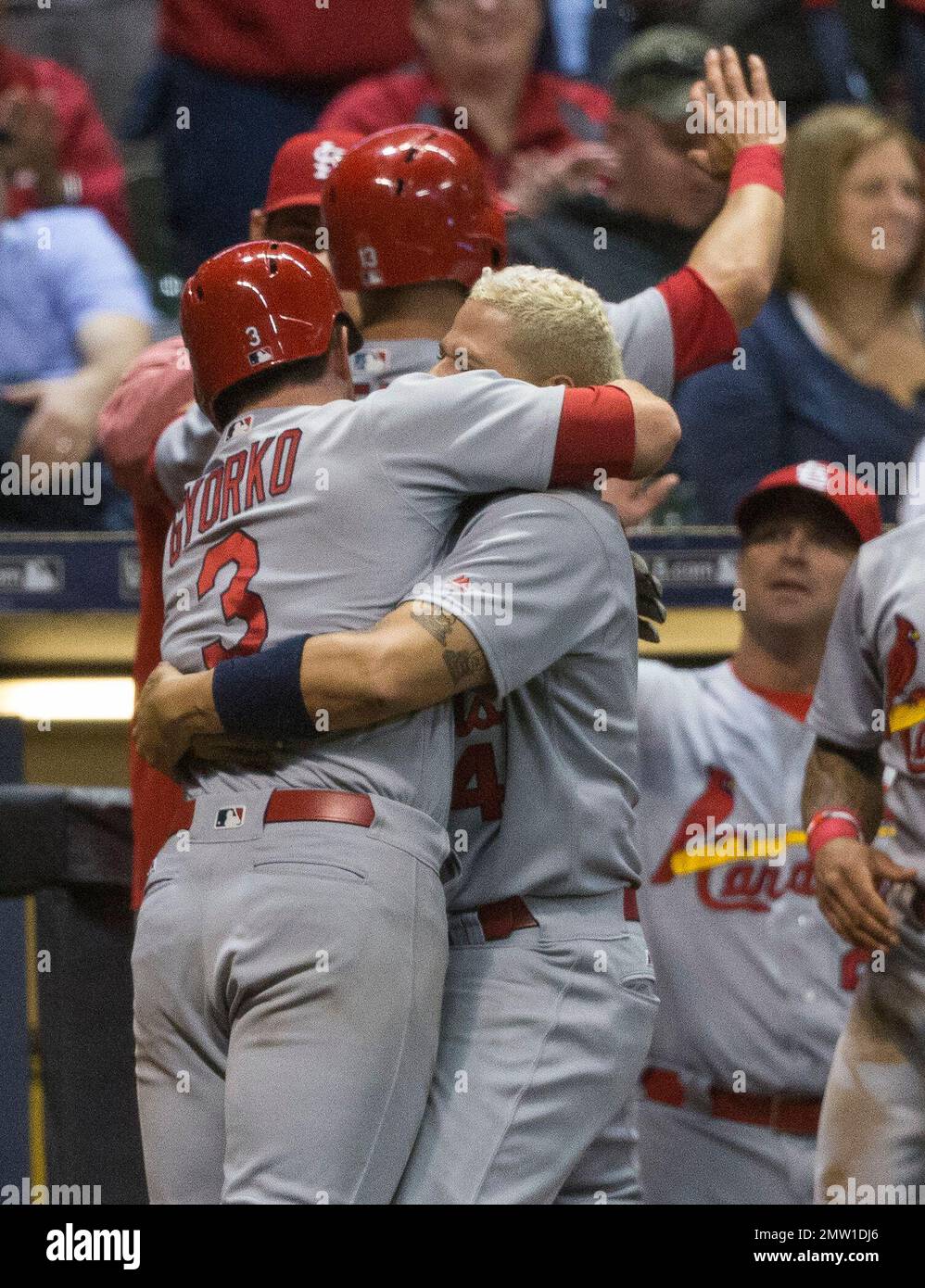 St. Louis Cardinals' Jedd Gyorko is hugged by Yadier Molina after hitting a triple and then