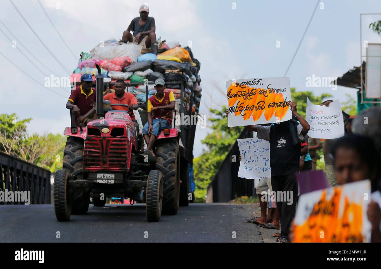 Sri Lankans residing in the Karadiyana garbage dump area hold placards