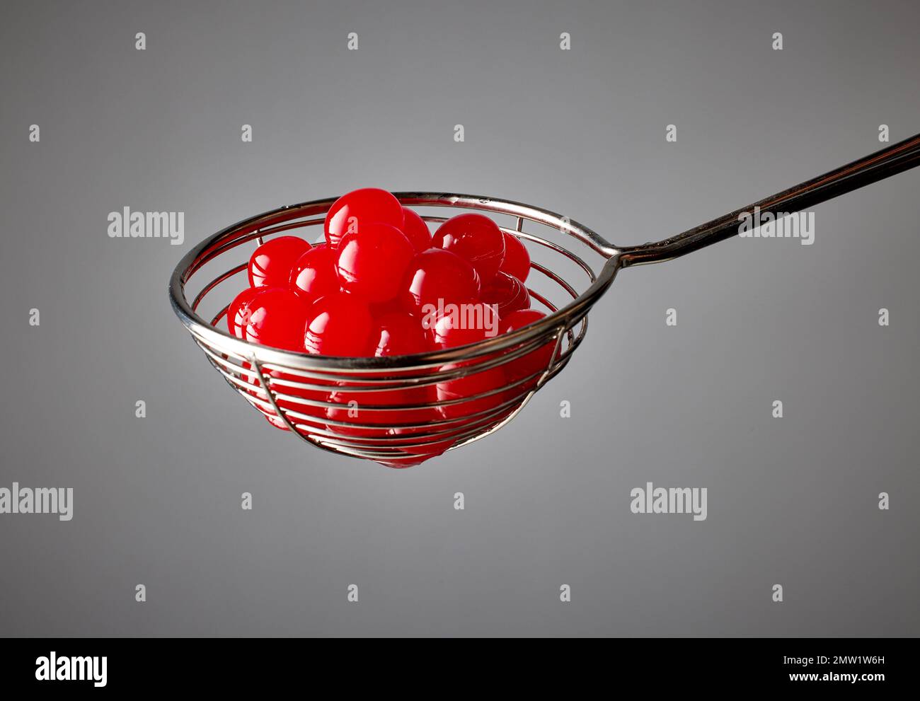 red jelly balls for making bubble tea in a strainer on grey background