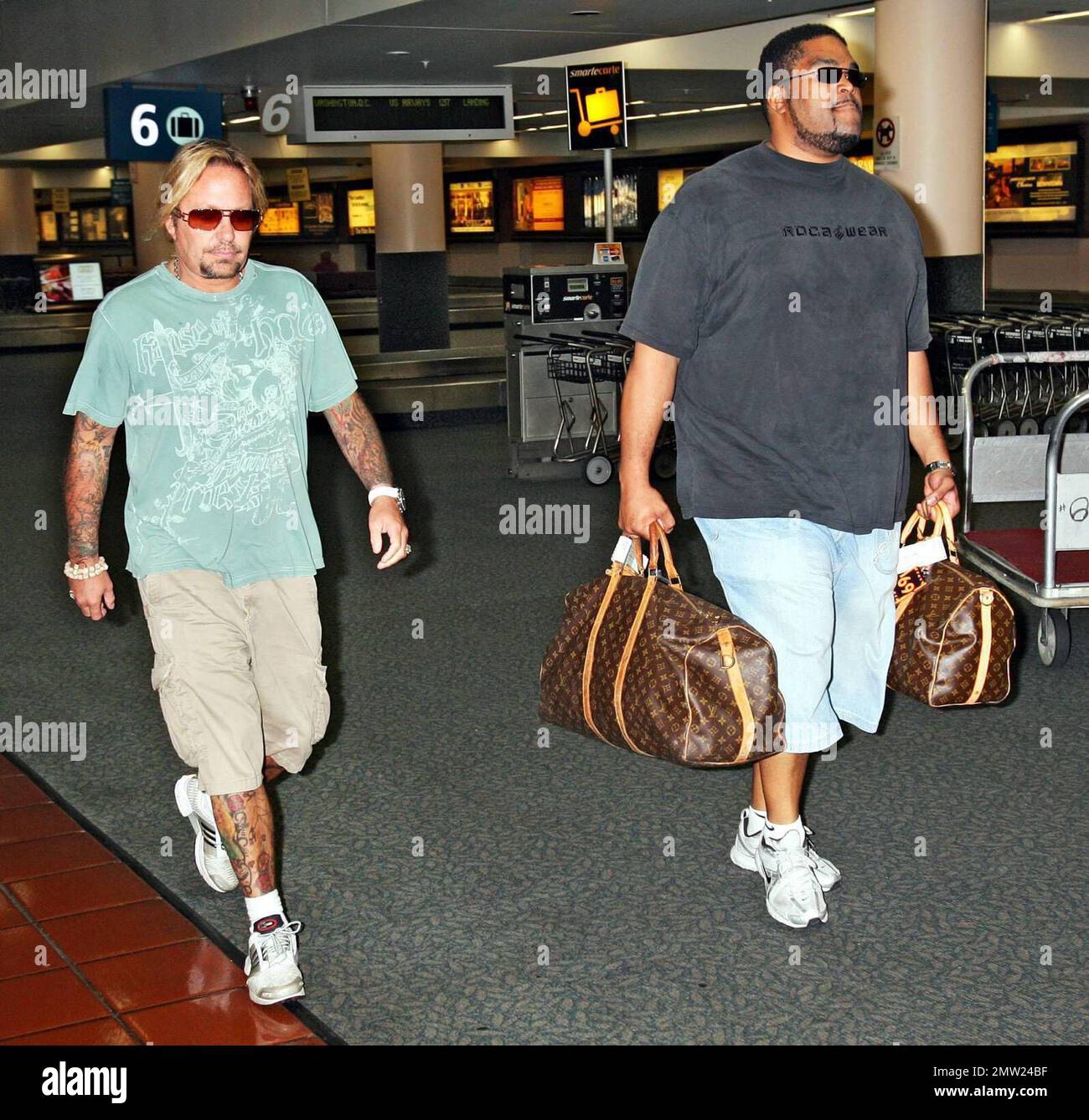 Exclusive!! Vince Neil arrives at Palm Beach International Airport and  strolls along with a bodyguard who carries his Louis Vuitton luggage. His  arrival is in advance of CrŸe Fest featuring Mštley CrŸe