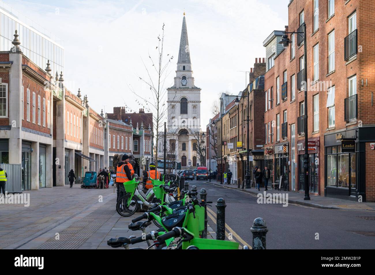 View along Brushfield Street towards Christ Church Spitalfields. Lime rental bikes in foreground. London, England, UK Stock Photo