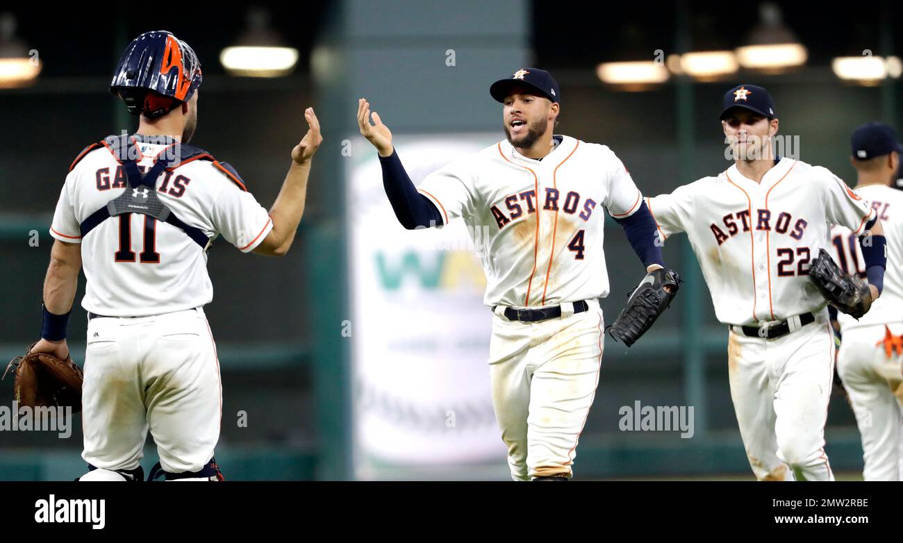 Houston Astros' George Springer (4) celebrates with catcher Evan Gattis  (11) after beating the Los Angeles