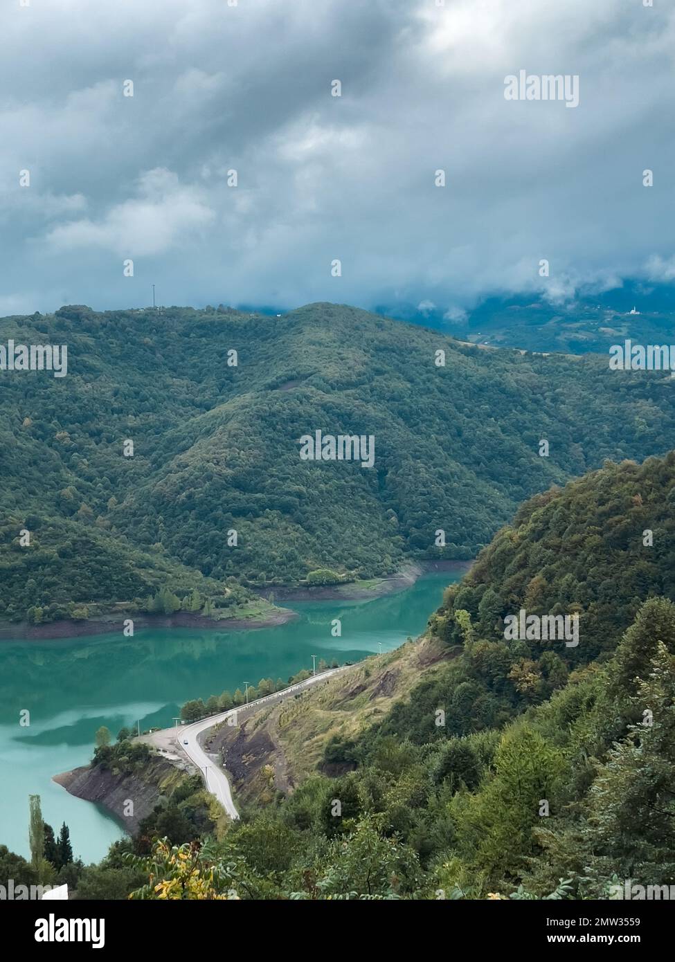 An aerial view of lake surrounded by mountains and dense trees Stock ...