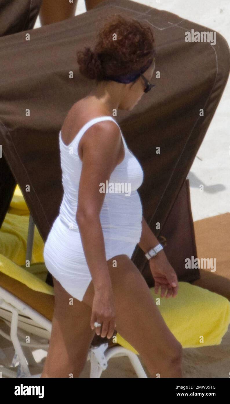 EXCLUSIVE!! R&B singer Whitney Houston, wearing a white swimsuit showing off her fuller figure, enjoys an afternoon at Atlantis Paradise Island beach with 17 year old daughter Bobbi Kristina and friends.   Houston, who turns 47 in two days time on August 9th, enjoyed a hot dog and fizzy drink before taking cover under her towel as she dashed inside her luxury hotel.  Nassau, Bahamas 08/07/2010    . Stock Photo