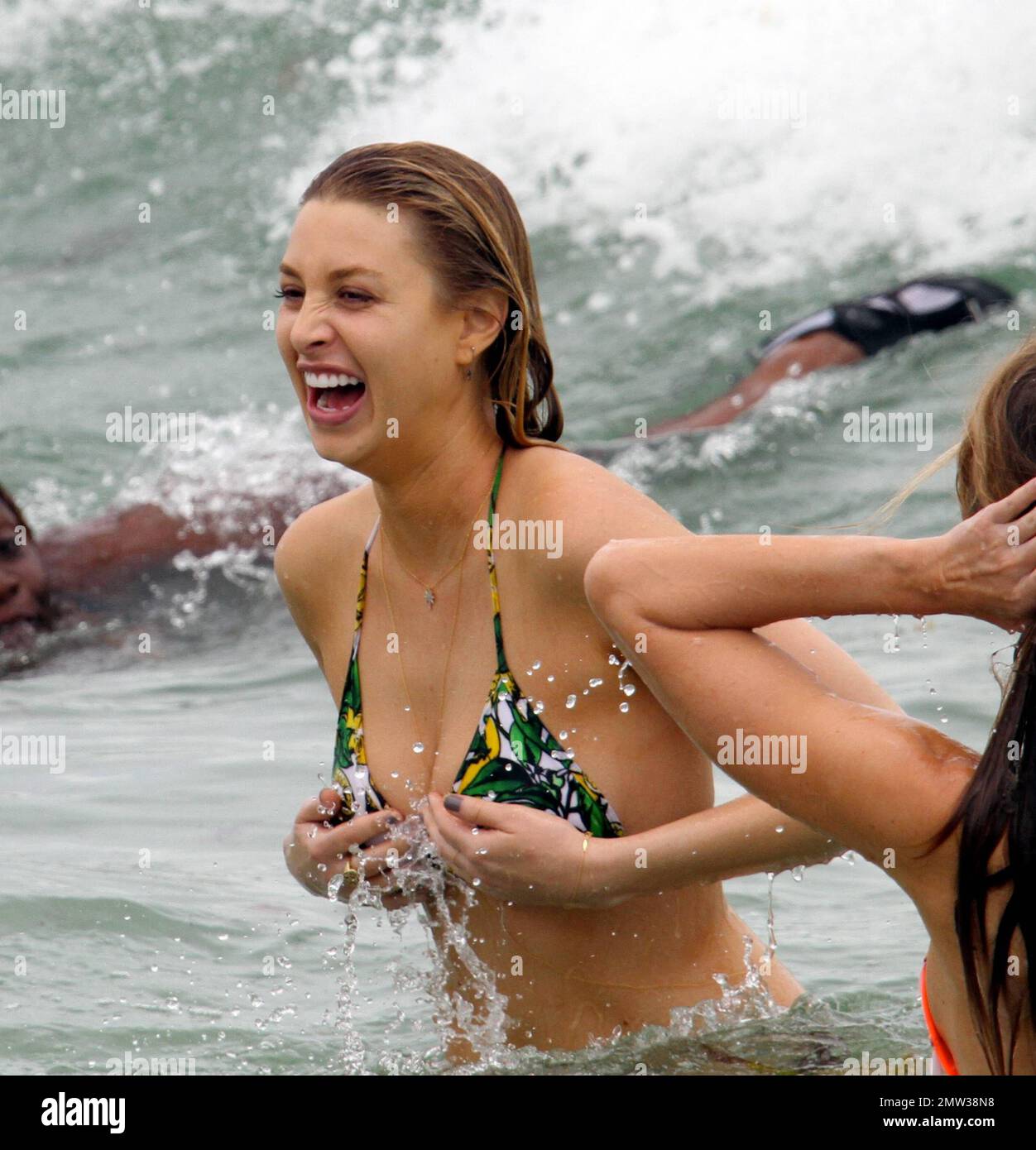 Whitney Port takes a dip in the ocean during a cloudy day in South Beach  with her pals. Port was wearing an American Apparel yellow and green two  piece with a gold