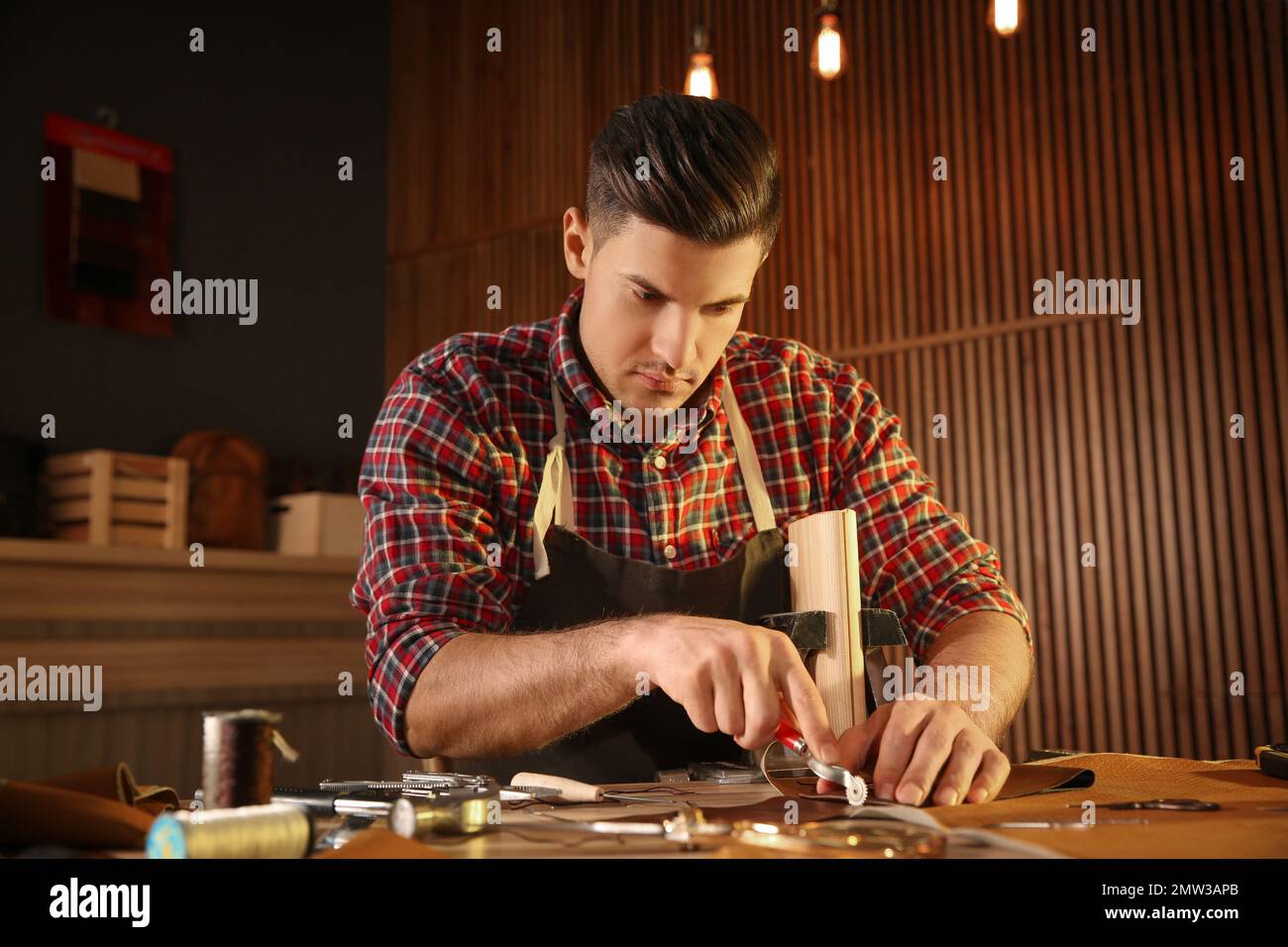 Man marking leather with roller in Stock Photo Alamy
