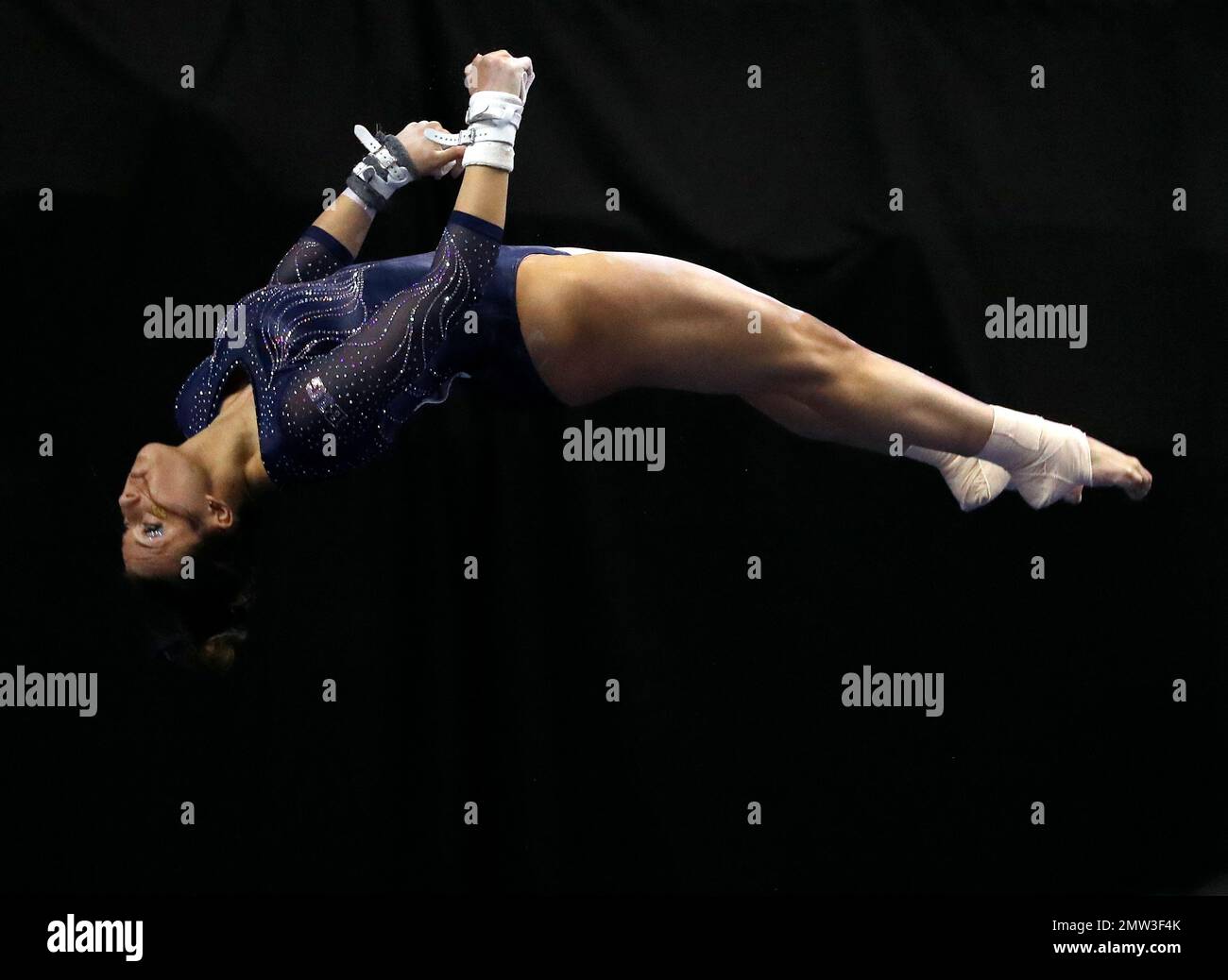 Michigan's Olivia Karas dismounts the uneven parallel bars during the