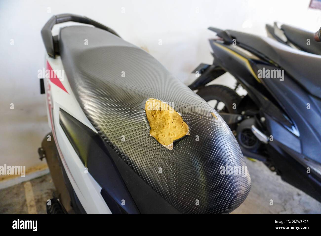 A hole in a motorcycle seat. Genuine leather upholstery has failed over