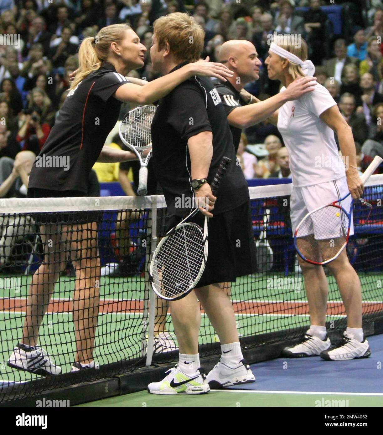Elton John kisses Stephanie Graf and Andre Agassi kisses Martina Navratilova after the four play a game of doubles at the 18th annual World Team Tennis (WTT) Smash Hits presented by GEICO,
