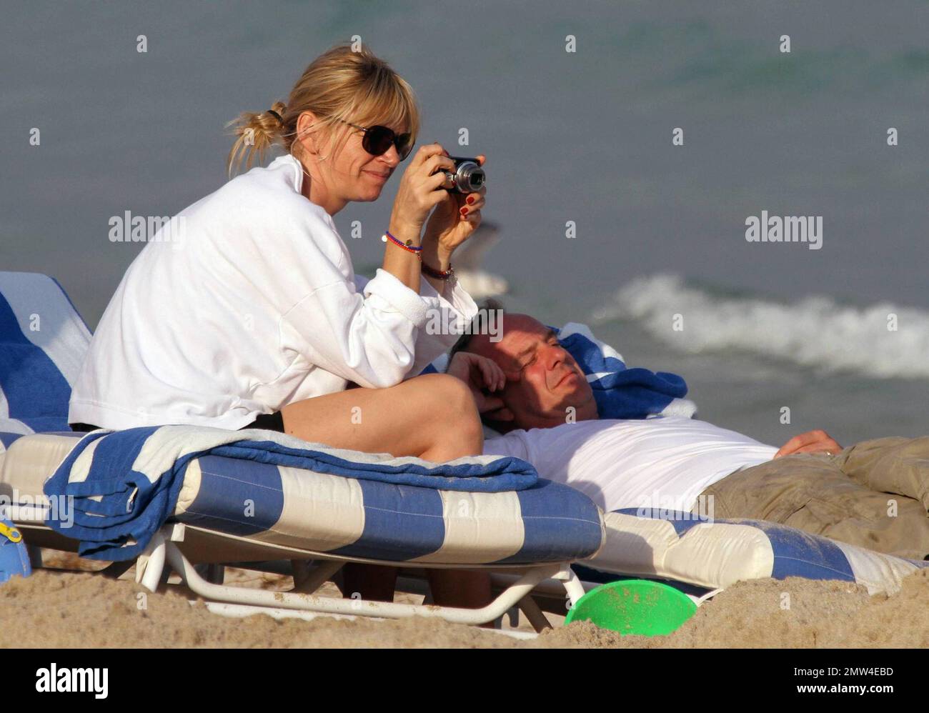 UK television personality Zoe Ball and husband Norman Cook (aka Fatboy Slim) enjoy an afternoon on the beach with their two children, Woody and Nelly. Father and son teamed up to dig a very deep hole in the sand and dad almost lost his pants getting out. Later, while Zoe was helping Woody climb out of the hole, Norman gave her a friendly shove into the hole. Miami Beach, FL. 1/4/11. Stock Photo