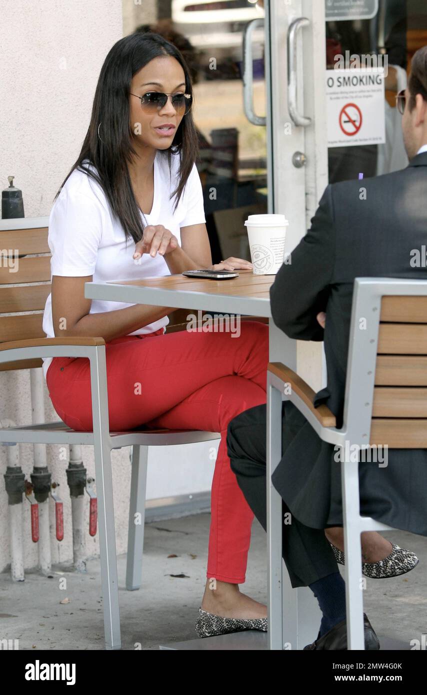 zoe saldana cigarette Actress Zoe Saldana wearing red A|X Armani Exchange jeans is all smiles as  she grabs a coffee with a male friend in Larchmont Village. Los Angeles,  CA. 24th August 2012 Stock Photo -