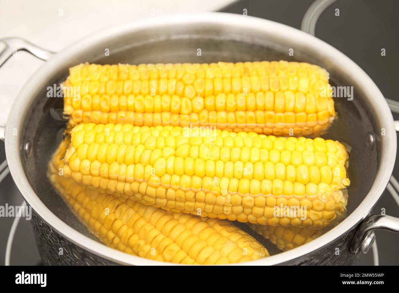 Pot with boiling fresh corn on cooktop, closeup Stock Photo - Alamy