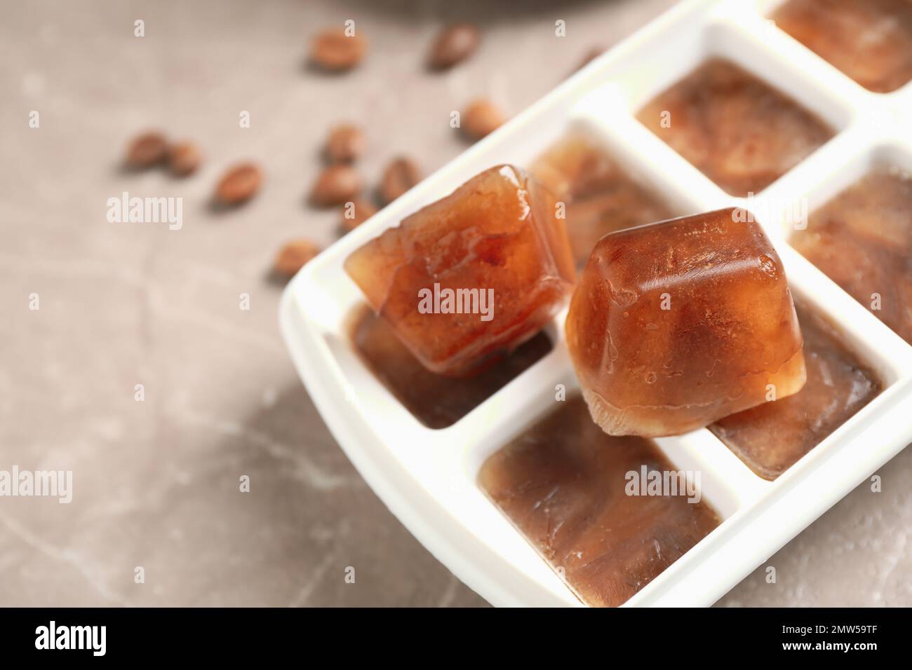 https://c8.alamy.com/comp/2MW59TF/ice-cube-tray-with-frozen-coffee-on-grey-table-closeup-space-for-text-2MW59TF.jpg