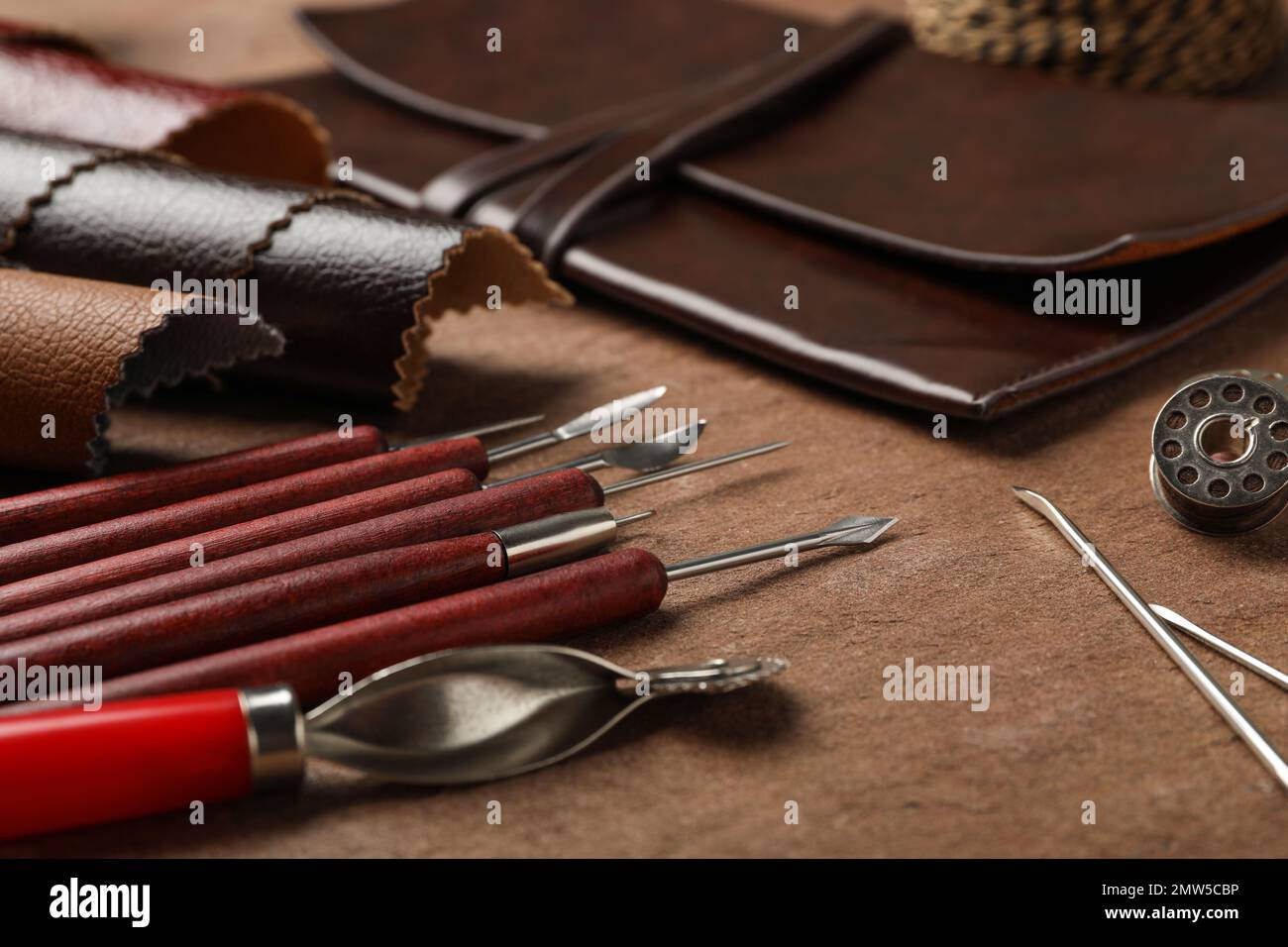 Leather samples and tools on brown table, closeup Stock Photo