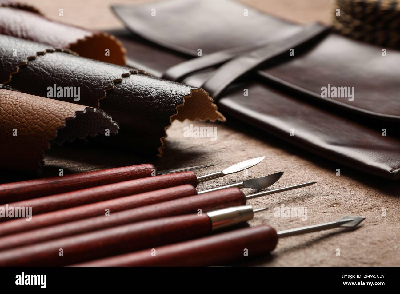 Leather samples and tools on brown table, closeup Stock Photo