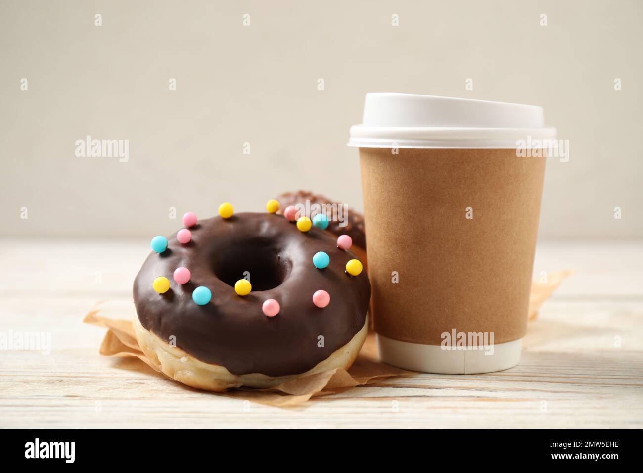 Delicious glazed donuts and coffee on white wooden table Stock Photo ...