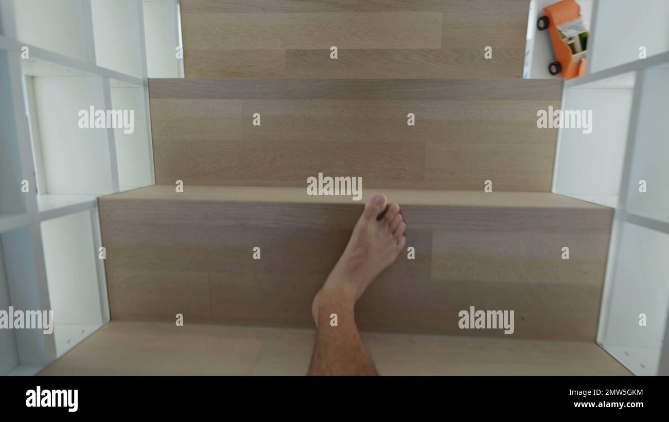 Person legs POV walking in home coming down the stairs. Point of view