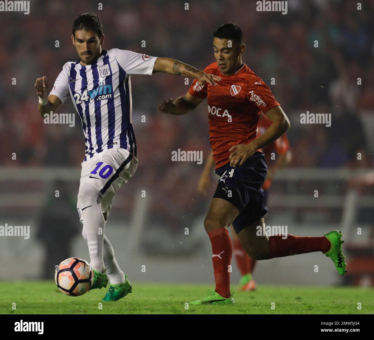 German Pacheco of Peru's Alianza Lima, left, fights for the ball with Nery Dominguez of Argentina's Independiente during a Copa Sudamericana soccer match in Buenos Aires, Argentina, Tuesday, April 4, 2017.(AP Photo/Natacha Pisarenko) Stock Photo