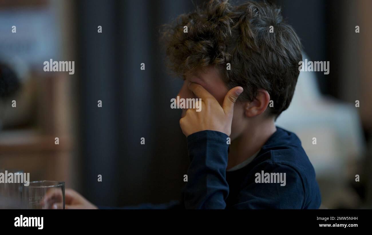 Young boy scratches eye with finger Stock Photo Alamy