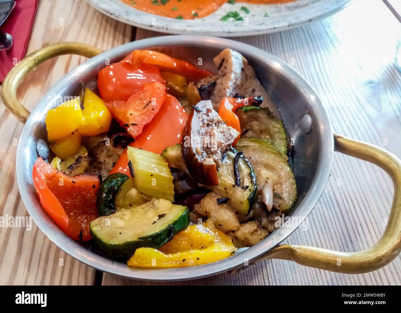 Italian cooked vegetable dish place on the restaurant dining table. Stock Photo