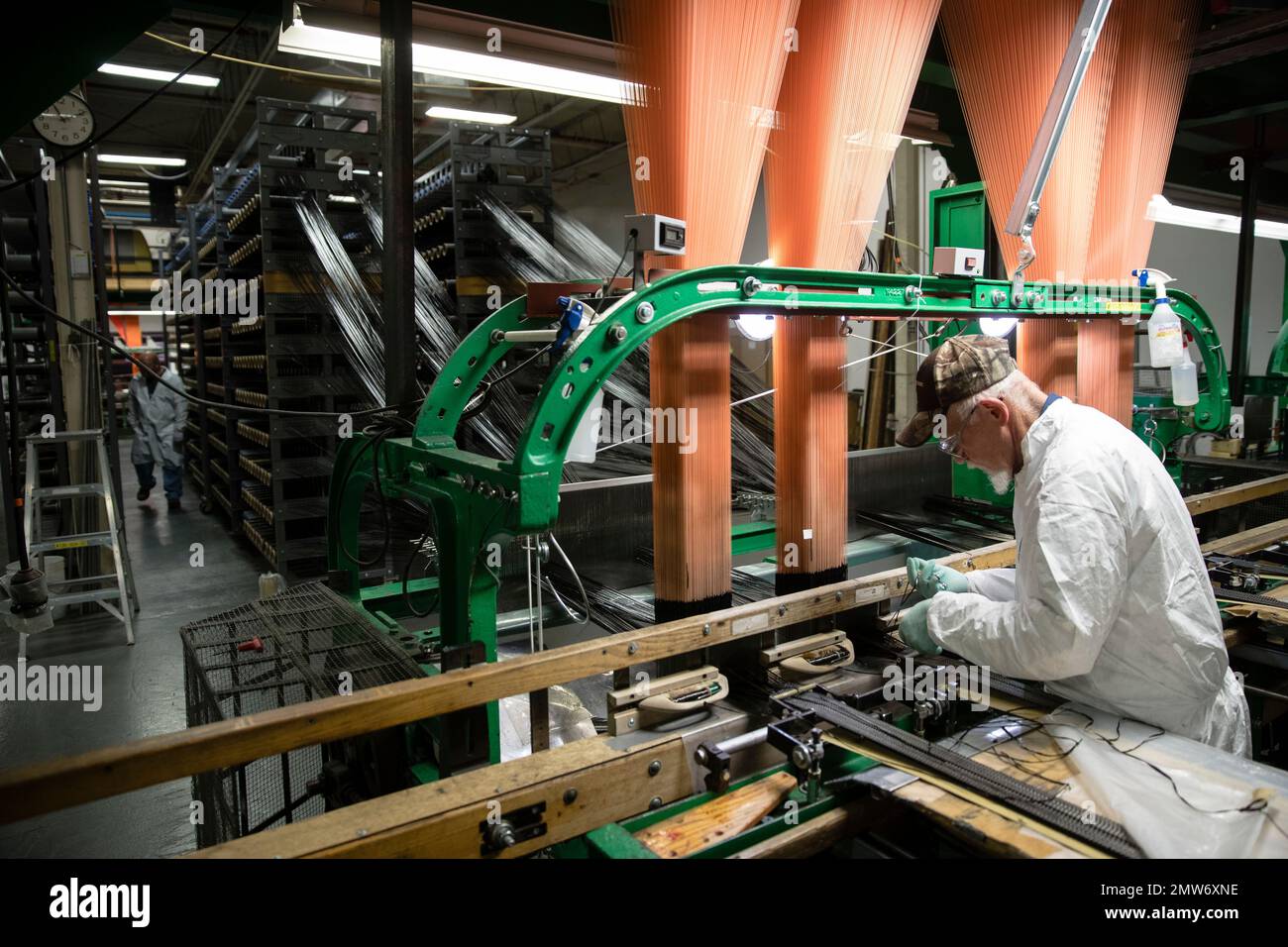 A workman operates a loom manufacturing composite parts for joints in