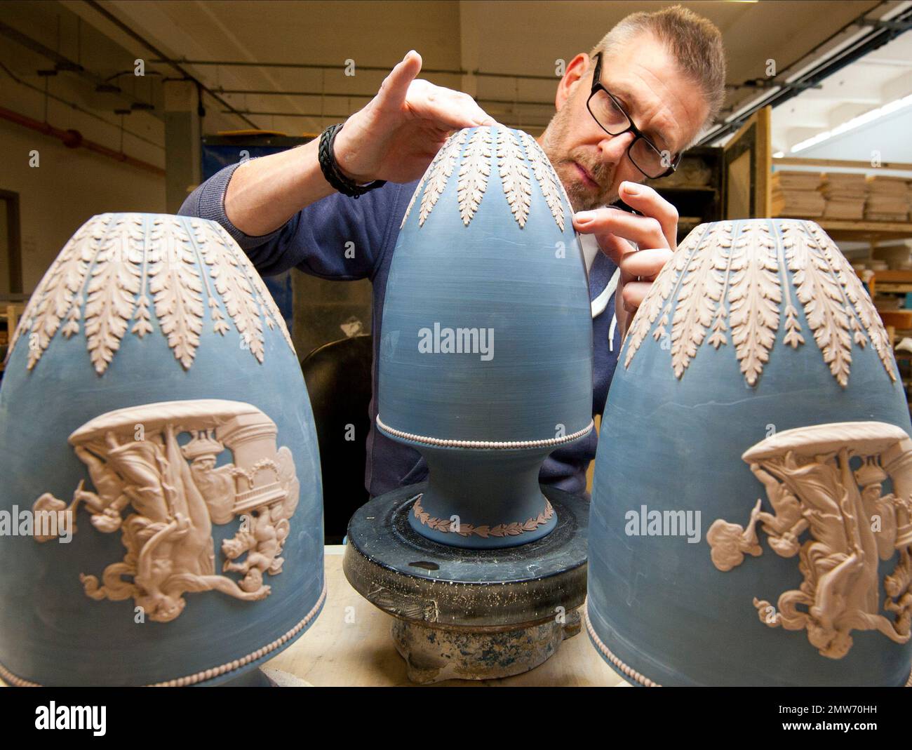 In this Monday, March 13, 2017 photo, a pottery worker puts final touches  on ornamental vases at Wedgwood factory, in Stoke on Trent, England.  Wedgwood has embarked on a sweeping revamp of