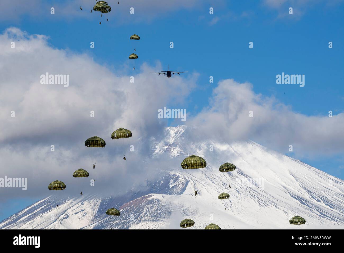 Shizuoka Prefecture, Japan. 31st Jan, 2023. Japan Ground Self-Defense Force paratroopers with the 1st Airborne Brigade descend from a U.S Air Force C-130J Super Hercules aircraft with snowcapped Mount Fuji behind at the East Fuji Maneuver Area, January 31, 2023 in Honshu, Japan. Credit: Yasuo Osakabe/U.S. Air Force/Alamy Live News Stock Photo