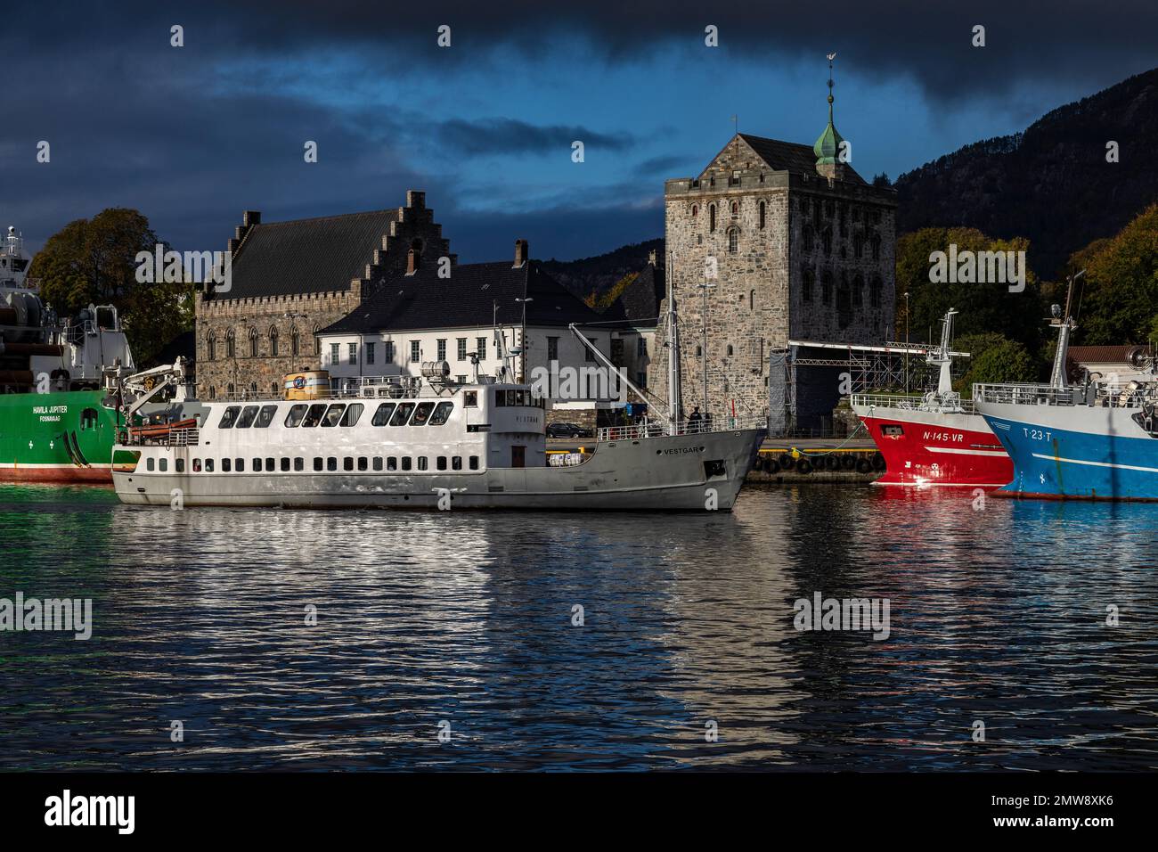 Veteran passenger vessel Vestgar, built 1957. Arriving in the port of Bergen, Norway. Ancient Haakons Hall and Rosenkrantz Tower in background. Stock Photo