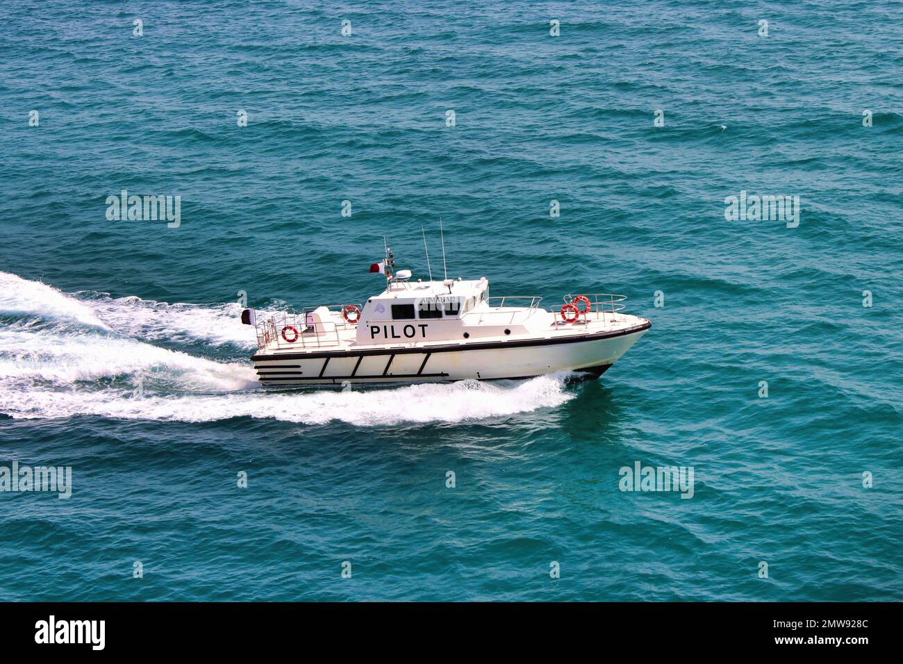 Pilot Boat underway approaching deep sea vessel Stock Photo