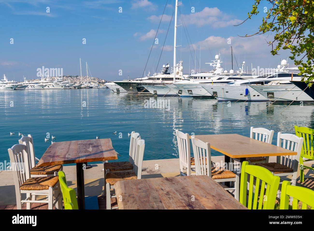 A sidewalk cafe table along the promenade of the Flisvos Marina and