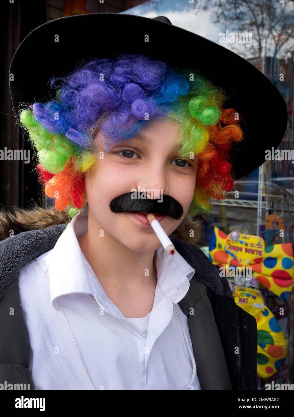 A boy wears a brightly colored wig and costume for the celebration of