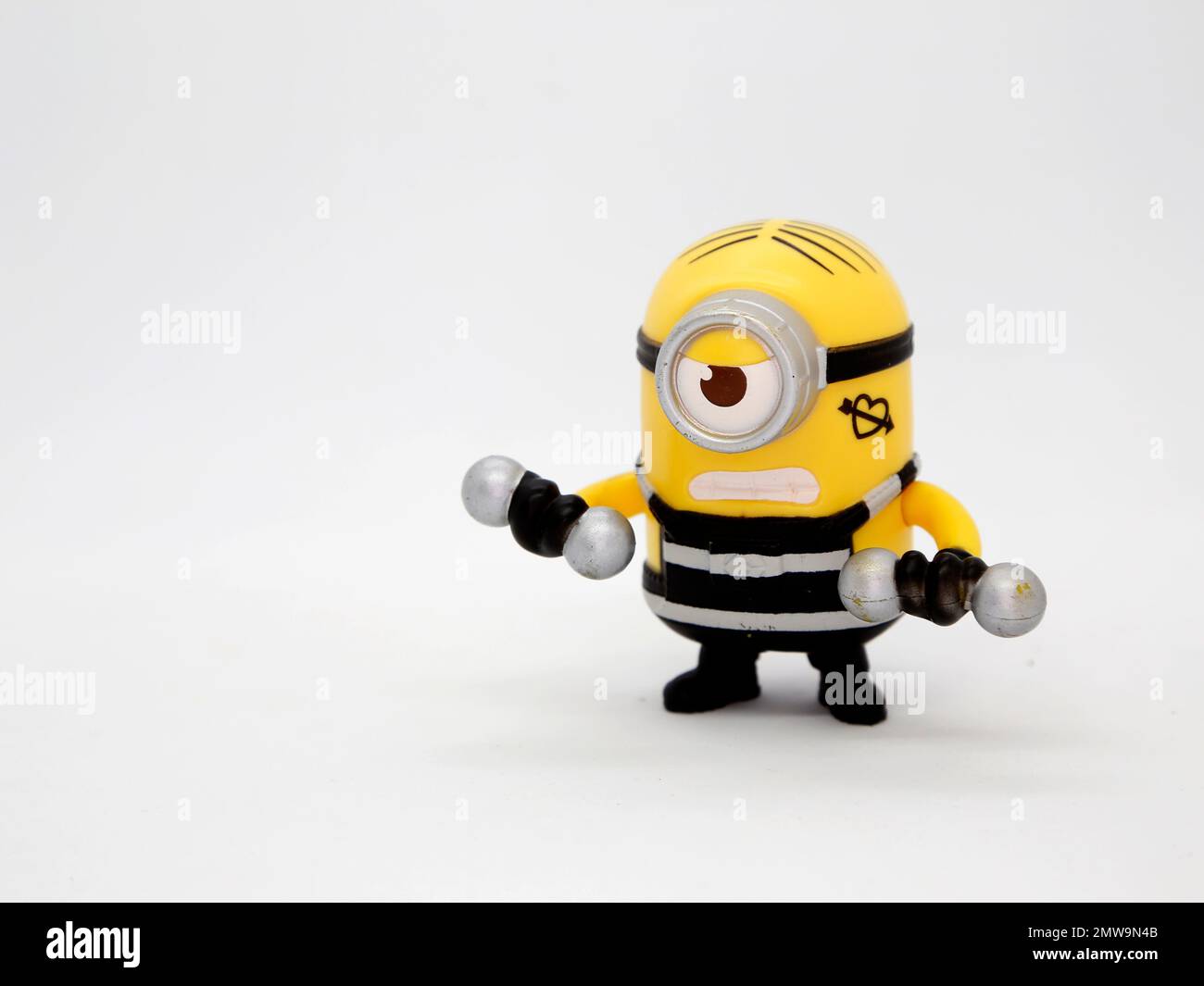 Prisoner minions lifting weights. Weightlifter. Minions prisoner dressed in striped suit and tattoos. Characters from the famous Despicable Me movies. Stock Photo