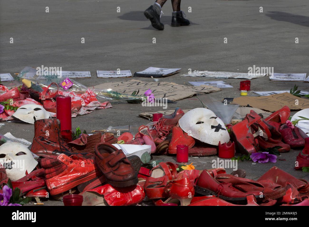 Red shoes, candles, flowers and masks placed by members of women's group  lie on the ground in Puerta del Sol square on the eve of International  Women's Day in Madrid, Spain, Tuesday,