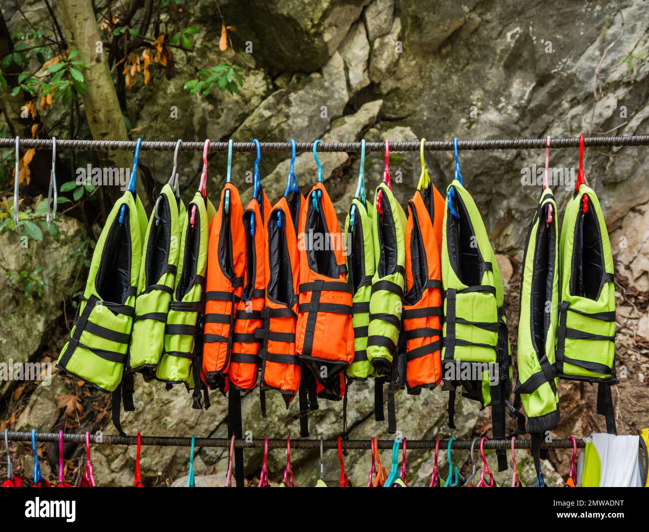 Bright life vests on clothing hanger. Lifesaving equipment for