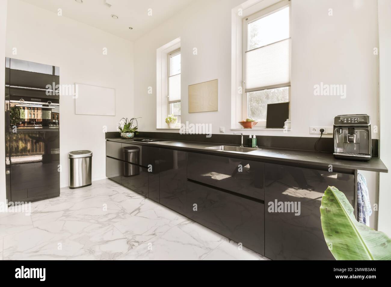 a modern kitchen with black cabinets and white marble countertops on ...