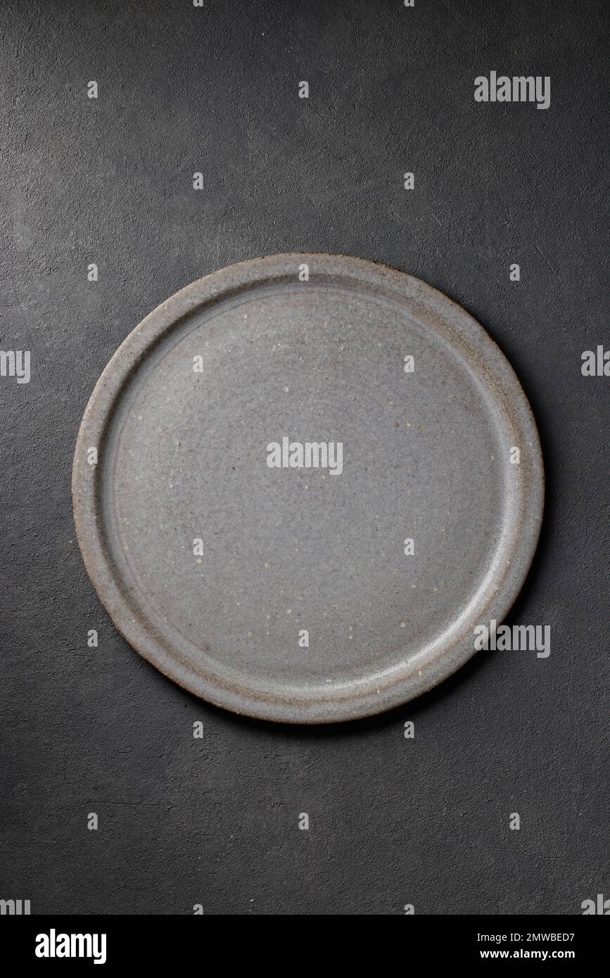 empty ceramic plate on dark grey table background, top view Stock Photo