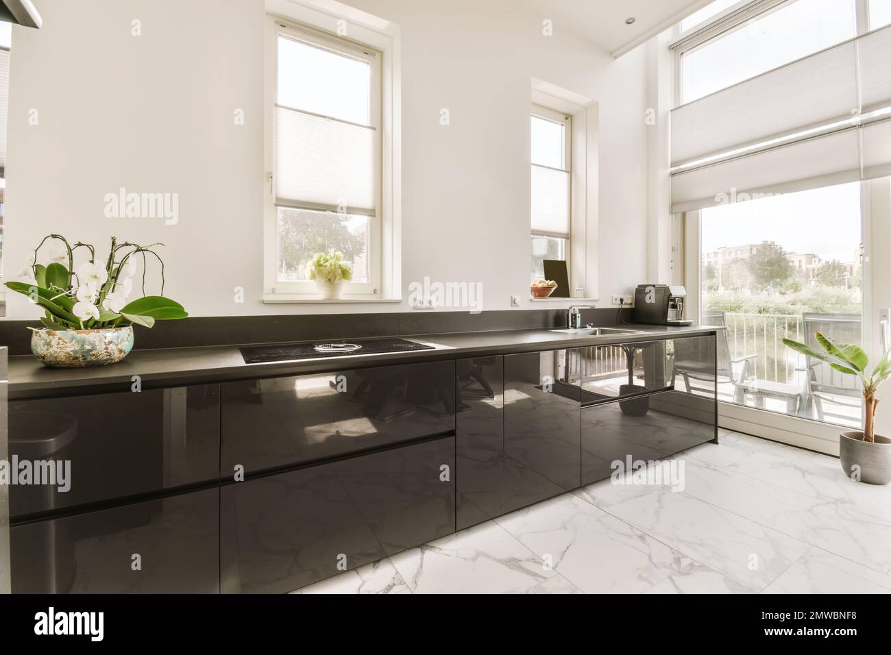 a modern kitchen with black cabinets and white marble countertops on ...