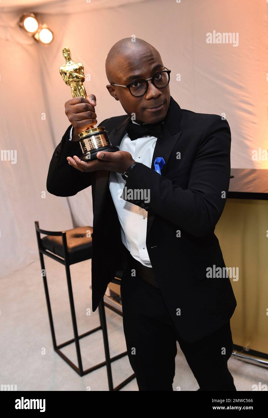 Barry Jenkins poses with the award for best adapted screenplay